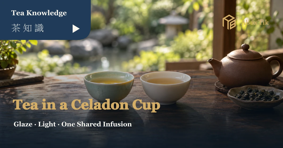 Celadon tea cup beside a white porcelain cup of tea, with a clay pot and dry leaves