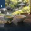青瓷茶杯与白瓷杯并排盛茶，旁有陶壶与干茶