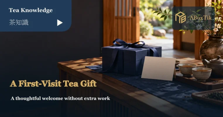 A navy gift box and blank card on a wooden cabinet