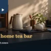 Compact home tea bar with tea packets, kettle, cups and a drip tray