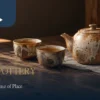 Illustrative Miaoli pottery tea setting with an ash-glaze style teapot and two cups on a wooden table