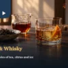 Black tea whisky with orange peel and ice beside brewed tea and dry black tea leaves