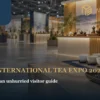 A quiet indoor tea-expo setting with white cups and warm exhibition light