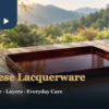 Taiwanese lacquerware setting with a reddish-brown tray and soft cloth, with ceramic teaware behind
