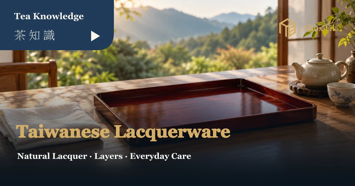 Taiwanese lacquerware setting with a reddish-brown tray and soft cloth, with ceramic teaware behind