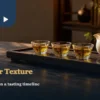 Three cups of golden tea beside a ceramic pitcher