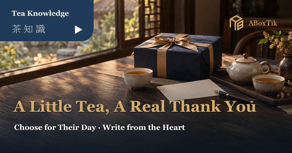 Thank-you tea gifts setting with a navy box, blank card, pen and two tea cups on a walnut table