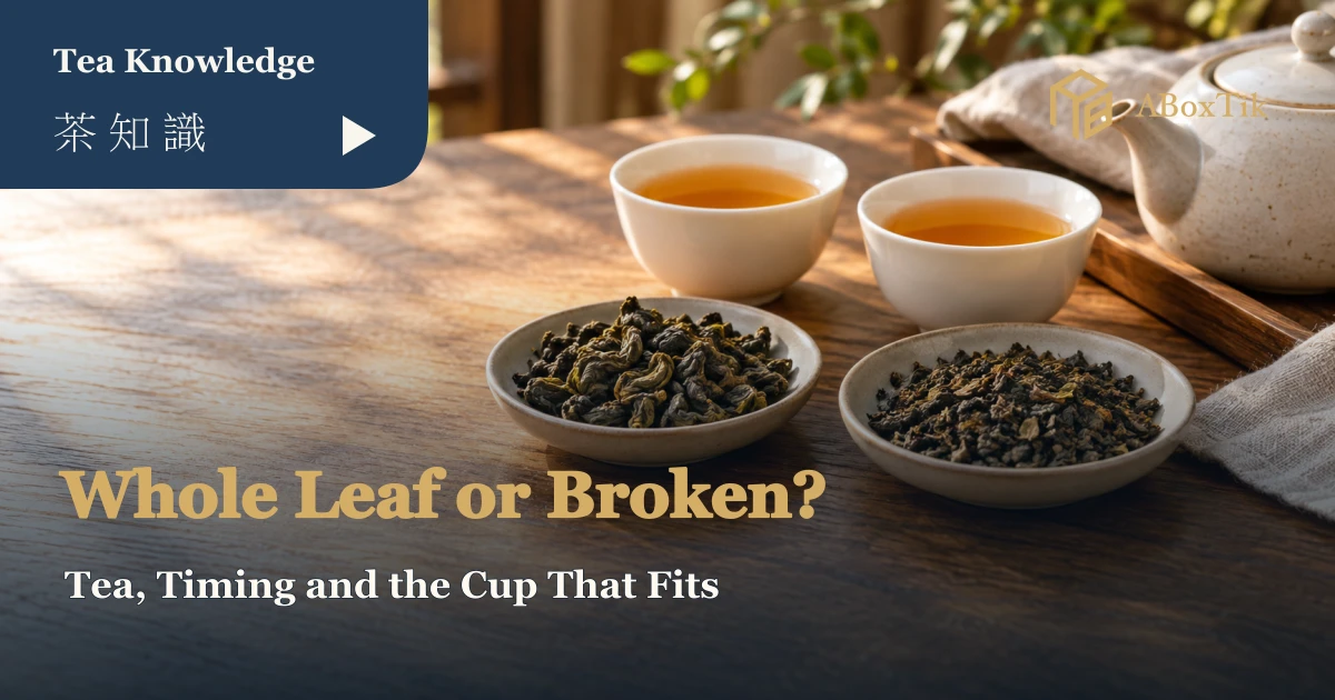 Two dishes of larger tea leaves and smaller pieces beside amber tea in warm light